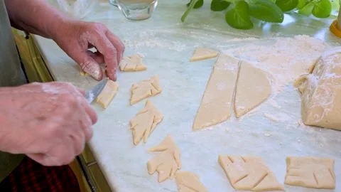 A man cuts rolled dough on a kitchen table. Stock Footage 307008725