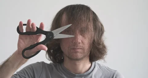 Man cuts with scissors in air. Long hair covering face. Concept solving problem Stock Footage 255818646