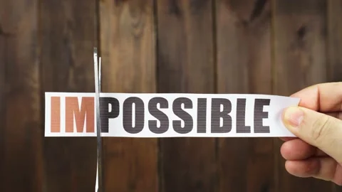 A man cuts with scissors a strip of paper with the inscription - IMPOSSIBLE Stock Footage 230013003