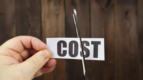 A man cuts with scissors a strip of paper with the inscription - COST Stock Footage 233490544
