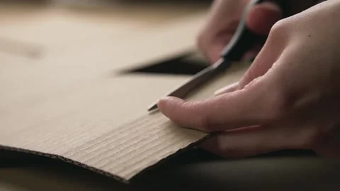 Man cuts a sheet of cardboard with scissors Video stock 143235691
