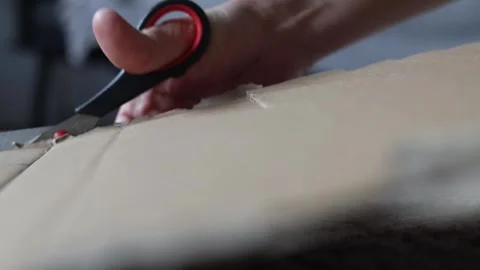 Man cuts a sheet of cardboard with scissors. Video stock 280306554