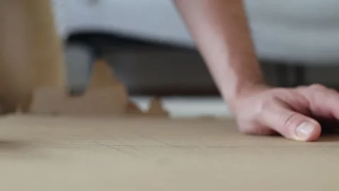 Man cuts a sheet of cardboard with a stationery knife. Video stock 280306523