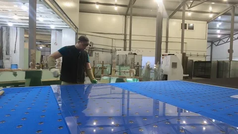 A man cuts the sheet of glass on the table.Glazier at work. Stock Footage 124803892