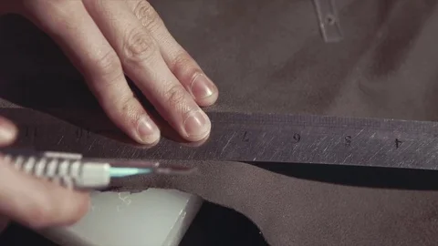 The man cuts the skin with a knife on the table Stock Footage 75704616