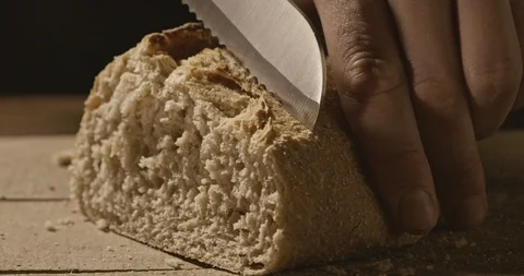A man cuts a soft bread with a bread knife on a wooden board Stock Footage 88796001