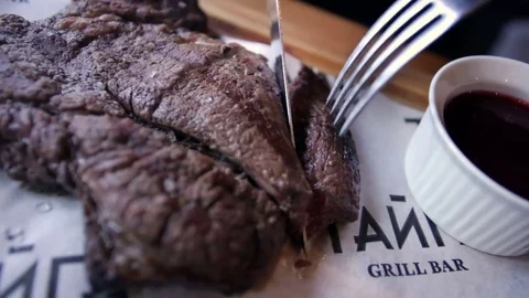 Man cuts a steak Stock Footage 77412490