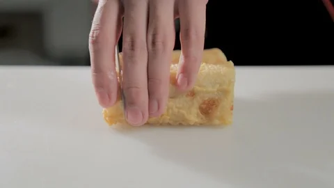 Man cuts a sushi roll with knife in restaurant. Roll lies on a board. 스톡 동영상 87233323