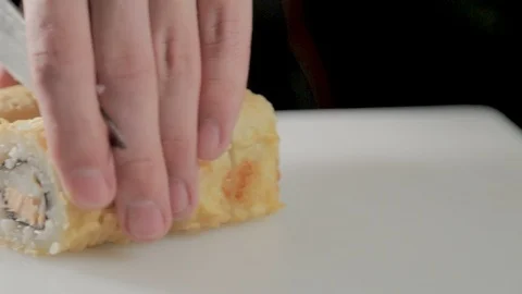 Man cuts a sushi roll on white table in restaurant.Close-up 스톡 동영상 87233301