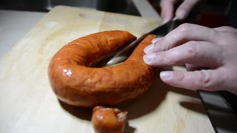 Man cuts into thin slices fatty sausage. Shooting closeup. Chef cutting salami w Vídeos de archivo 128621508