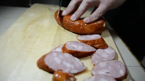 Man cuts into thin slices fatty sausage. Shooting closeup. Chef cutting salami w Vídeos de archivo 128621513