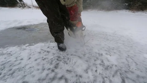 Man cuts through ice with chainsaw Stock Footage 77280448