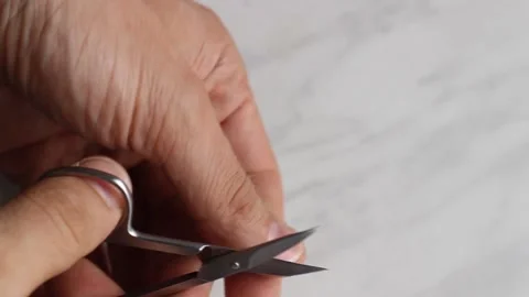Man cuts a thumbnail with scissors Stock Footage 131567389