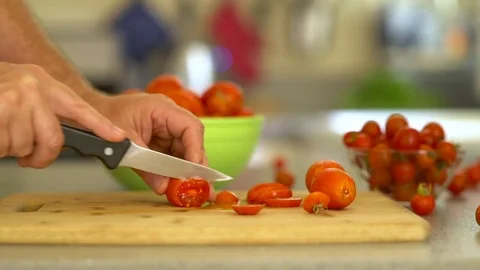 Man cuts tomato on cutting board Slowmo Stock Footage 77327436