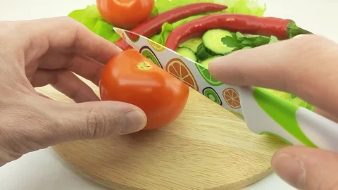 A man cuts a tomato Stock Footage 125354677