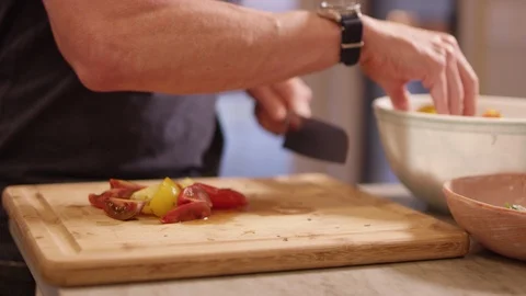 Man cuts tomatoes in nice kitchen Video stock 113476658