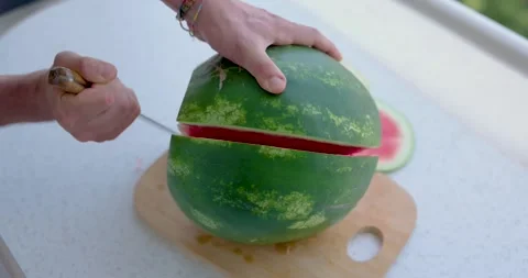 Man Cuts Watermelon In Half With Large Knife 4K Slow Motion Stock Footage 279655695