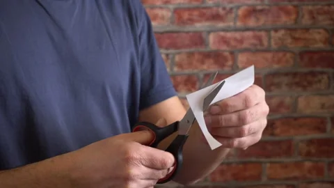 Man cuts white paper with scissors 4K Video stock 150287031