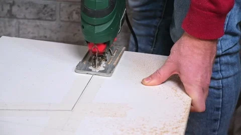 A man cuts a window sill from board for a window using an electric jigsaw for Video stock 168648426