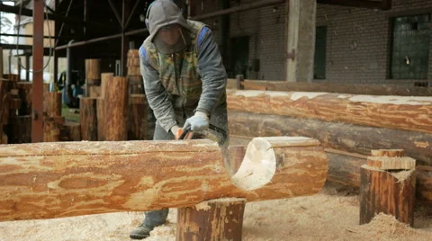 Man cuts wood chainsaw for future home. Protective face mask on the face of the Stock Footage 69065098