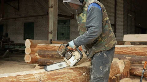 Man cuts wood chainsaw for future home. Protective face mask on the face of the Stock Footage 69067655