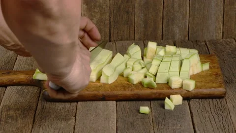 Man cuts zucchini into cubes. Side view. Stock Footage 164056270