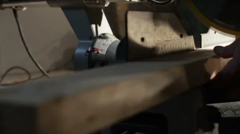 Man cutting a 2x4 of wood with a mitre saw Stock Footage 40648605