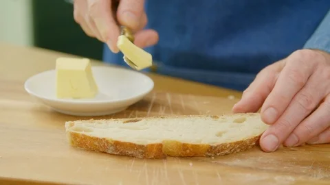 Man Cutting And Applying Butter On Bread With Knife Stock Footage 86072383