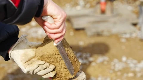 Man cutting and cleaning soil sample for laboratory analysis. Preparation of Stock Footage 312671807