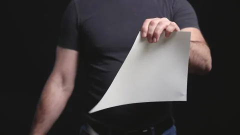 Man cutting and folding a blank sheet of paper Видео 309032371