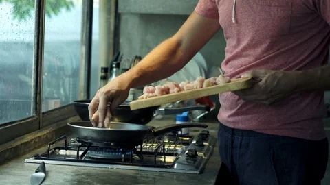 Man cutting and putting meat on the pan. Stock Footage 73145199