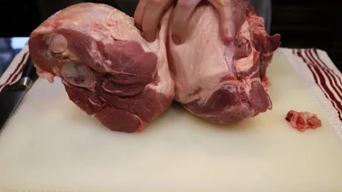 Man Cutting and trimming Large Pork Meat In A Kitchen With Two Knives Video stock 140554064