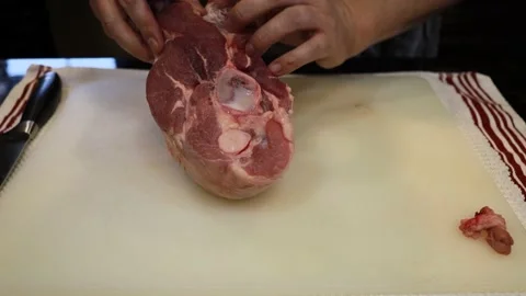 Man Cutting and trimming Large Pork Meat In A Kitchen With Two Knives Stock Footage 140555147