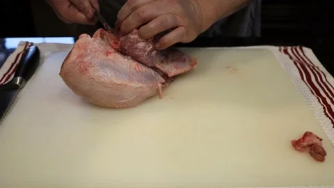 Man Cutting and trimming Large Pork Meat In A Kitchen With Two Knives Stock Footage 140555347