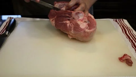 Man Cutting and trimming Large Pork Meat In A Kitchen With Two Knives Video stock 140555355