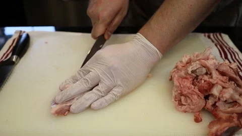 Man Cutting and trimming Large Pork Meat In A Kitchen With Two Knives Stock Footage 140565225