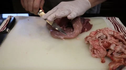 Man Cutting and trimming Large Pork Meat In A Kitchen With Two Knives Video stock 140569824