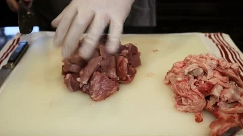 Man Cutting and trimming Large Pork Meat In A Kitchen With Two Knives Stock Footage 140569927