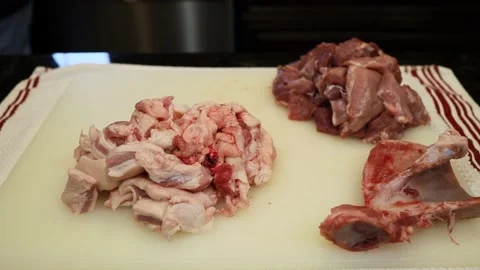 Man Cutting and trimming Large Pork Meat In A Kitchen With Two Knives Video stock 140571630
