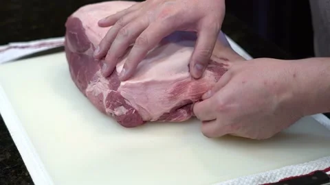 Man Cutting and trimming Large Pork Meat In A Kitchen With Two Knives Stock Footage 140598209