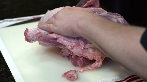 Man Cutting and trimming Large Pork Meat In A Kitchen With Two Knives Stock Footage 140599651