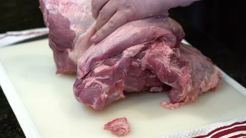 Man Cutting and trimming Large Pork Meat In A Kitchen With Two Knives Stock Footage 140599668