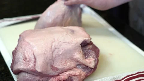 Man Cutting and trimming Large Pork Meat In A Kitchen With Two Knives Stock Footage 140600090