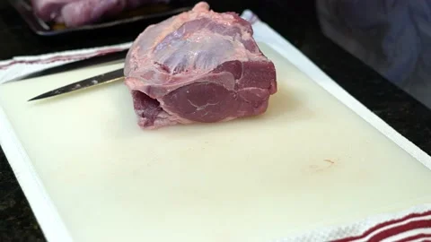 Man Cutting and trimming Large Pork Meat In A Kitchen With Two Knives Video stock 140600290