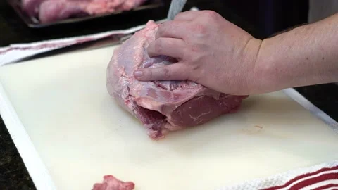 Man Cutting and trimming Large Pork Meat In A Kitchen With Two Knives Stock Footage 140600558