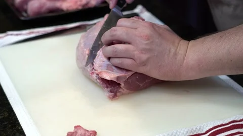 Man Cutting and trimming Large Pork Meat In A Kitchen With Two Knives Stock Footage 140600604