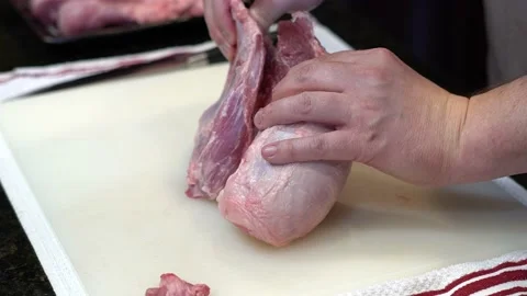Man Cutting and trimming Large Pork Meat In A Kitchen With Two Knives Stock Footage 140601021