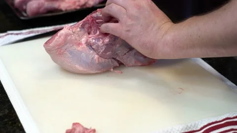 Man Cutting and trimming Large Pork Meat In A Kitchen With Two Knives Stock Footage 140601286