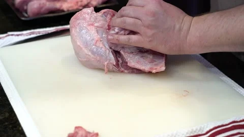 Man Cutting and trimming Large Pork Meat In A Kitchen With Two Knives Stock Footage 140601445