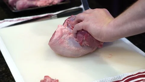 Man Cutting and trimming Large Pork Meat In A Kitchen With Two Knives Stock Footage 140601485